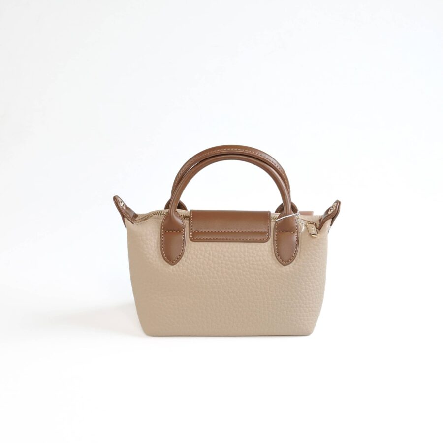 Sac à main beige avec poignées en cuir marron, parfait pour un style chic et fonctionnel..