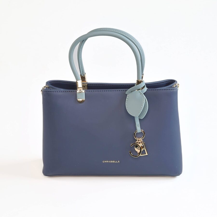 Sac à main en cuir bleu marine avec poignées contrastantes et pendentif orné de lettres..