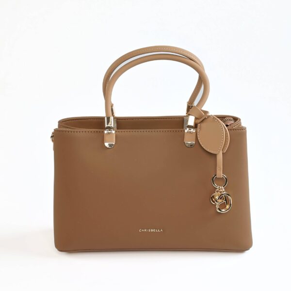 Sac à main en cuir beige avec charms dorés, parfait pour un look chic et sophistiqué..