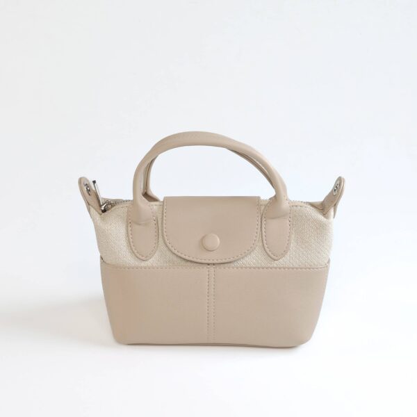 Sac à main beige en cuir synthétique avec poignée robuste et fermeture sécurisée..