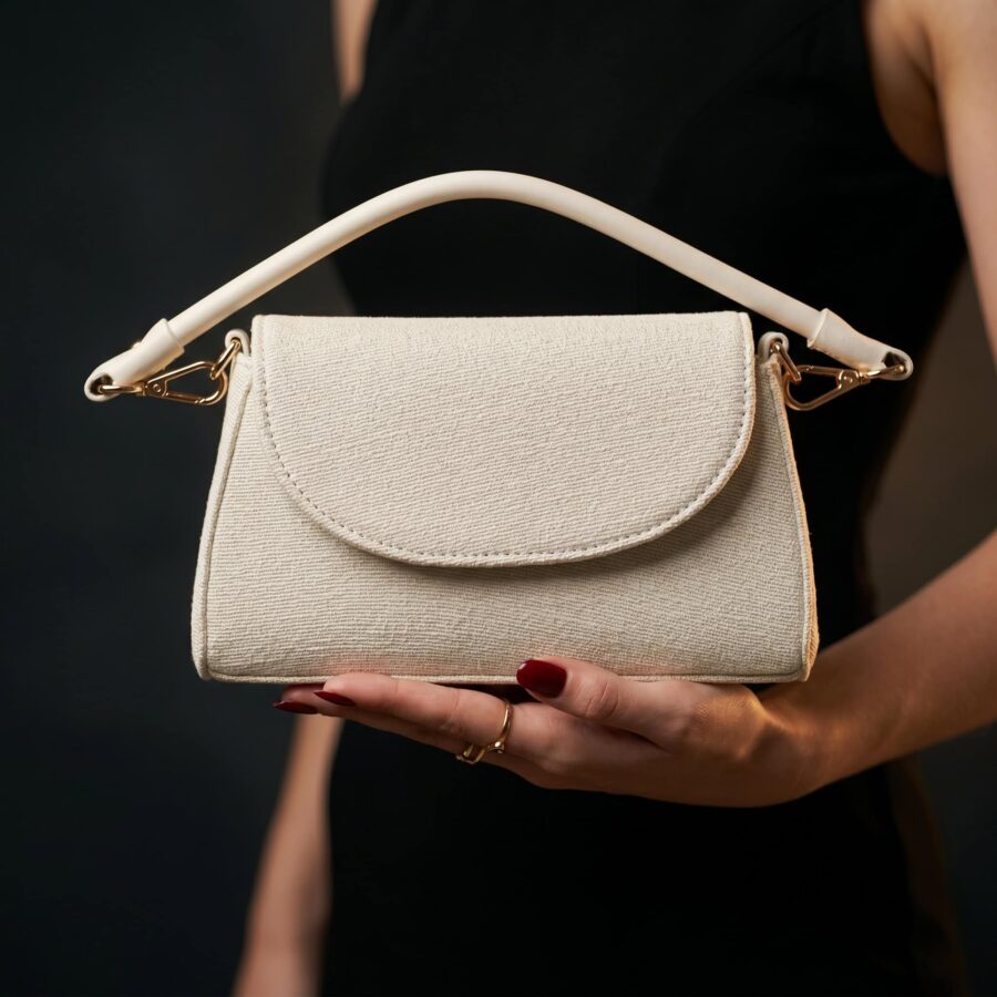 Sac à main en tissu beige avec poignée blanche, accessoire mode pour femmes..