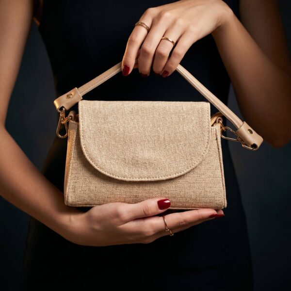 Sac à main en lin beige avec poignée en cuir naturel, parfait pour un look chic et décontracté..